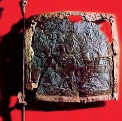 Image of a bronze flag with a faded design